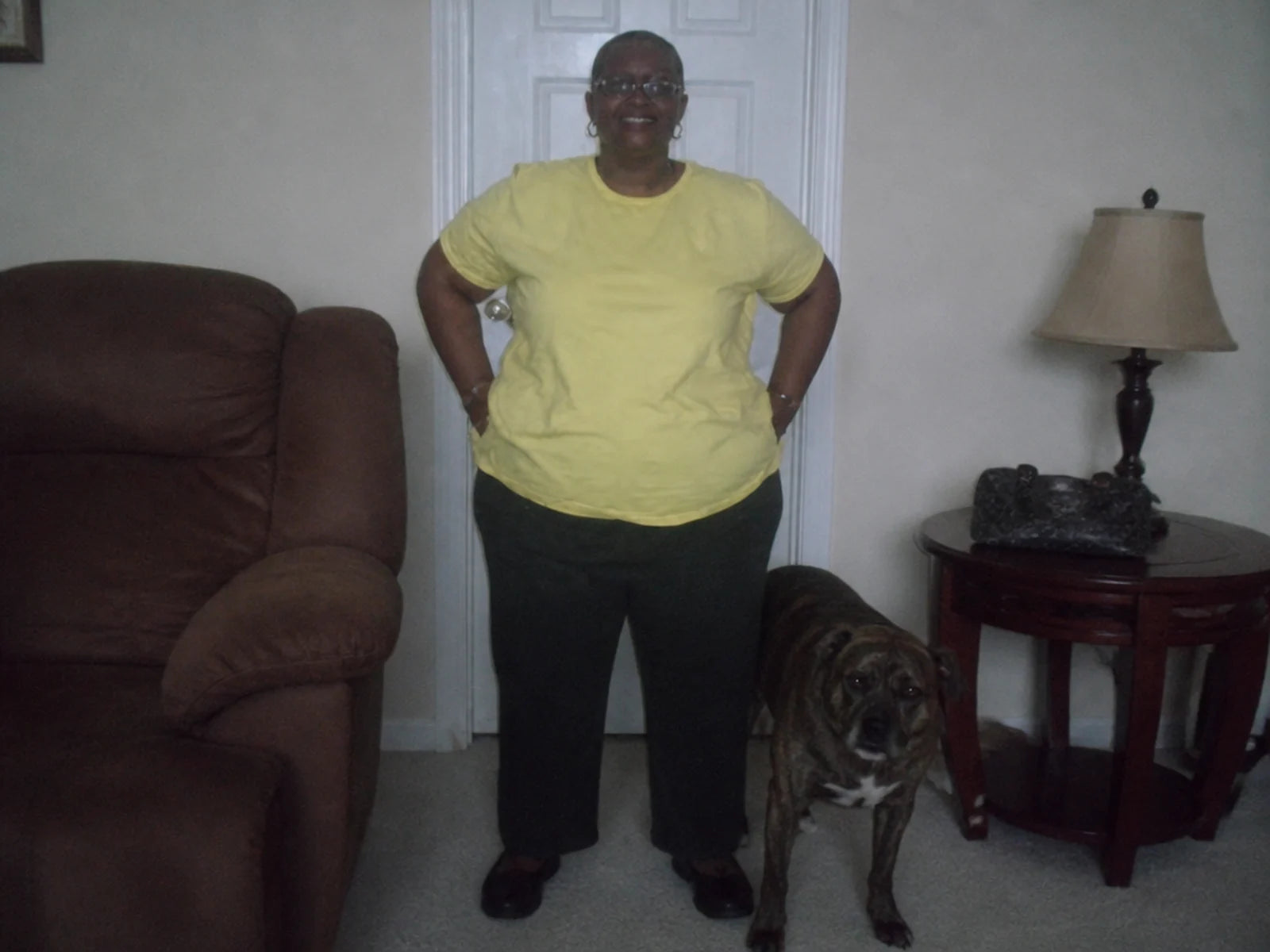 A customer standing in their living room beside their brindle dog