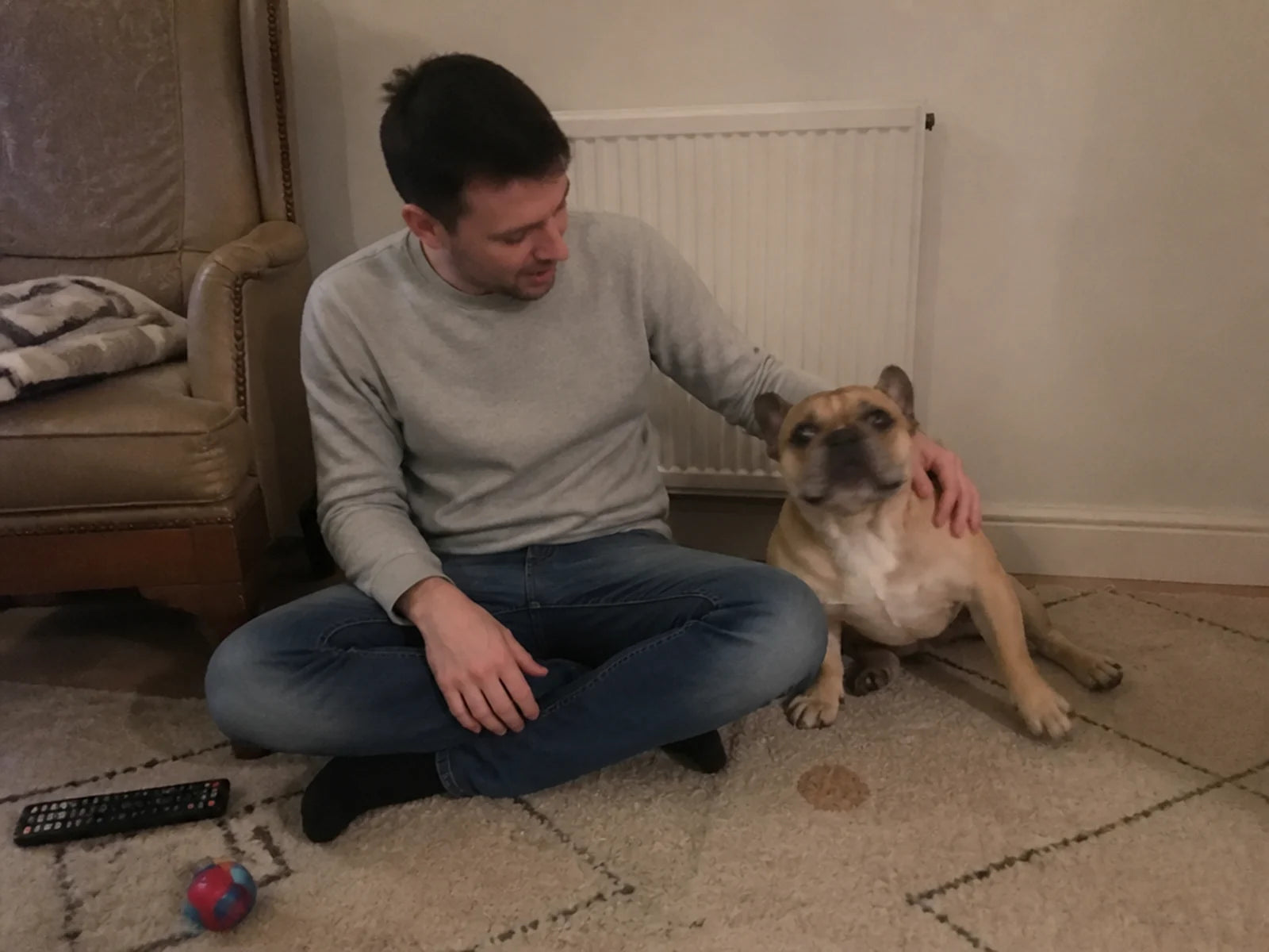 Colson with his fawn French bulldog on the living-room rug